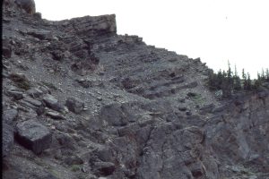 Turbidites overlie the main Todagin channel-fill conglomerate, about 10m thick, capped by a smaller channel. Note the slump discordance in the lower cycle.  Bowser Basin, British Columbia.