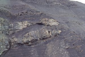 A closer view of the shelfbreak gully margin (Tsatia Mt), showing numerous discordant contact within the underlying slope mudrock facies, and minor slumping of the gully fill. At least two major episodes of fill are recorded here. Bowser Basin, British Columbia. The shelf-slope break coincides with the top of the gully conglomerate. Overlying shelf deposits are cyclical (parasequence scale).