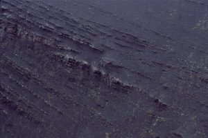 Slump-induced, listric-style fault in slope mudrocks, Tsatia Mt.  The fault flattens out along a thin turbidite bed; displacement decreases towards the fault tip at top right, where overlying beds are continuous. Bowser Basin, British Columbia.