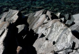 Shallow subtidal to intertidal, 2D subaqueous dunes in sandstone, Rowatt Fm, Belcher Islands (Aphebian, about 2 billion years old). Amplitude is 12-15 cm. Paleoflow was to the right. Hammer for scale.