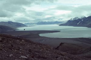 A sizeable fan delta encroaching into Tanquary Fiord, Ellesmere Island. Arrow points to a Geological Survey of Canada base camp in 1988 (arrow). The gravel delta top and foreslope are derived from Paleozoic rocks.