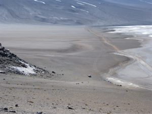 Alluvial fan lobes encroaching a gypsum-halite salar, Atacama, northern Chile. Right image shows an elevated fan (left centre) that represents deposition during a phase of higher lake levels; the older fan is now partly degraded. The cuspate and indented distal fan margin record a succession of fan lobes. Grey-brown colours reflect basalt-andesite clast compositions, enhanced by desert varnish.