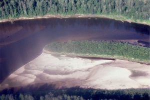 Active sand bars attached to a semi-permanent, vegetated bar, mid-stream, Clearwater River, Alberta.  This is a possible candidate for an anastomosing river. The submerged bar top also contains smaller subaqueous dunes. Flow to the left.