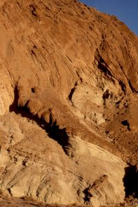 Hole in the Wall, Death Valley. Here, lacustrine sands and muds contain sporadic debris flows (resistant unit). Right image shows debris flow scours. They accumulated during Miocene-Pliocene extension  that resulted in Death Valley basin subsidence. Subsequent deformation took place as the Furnace Creek strike-slip fault created an en echelon stack of fan deltas and associated lacustrine deposits.