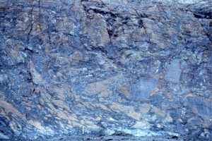 A bedding view (looking down on the flow top) of brecciated, folded and generally squished basalt fragments on top of a lava flow, that formed as the flow cooled, and were carried along the top of the flow. The oblique grooves across the rock face were formed by glacial scouring.  