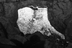 Closer view of small lava tube. Lava in the tube must have drained, leaving an open tube that was subsequently filled by very coarse calcite crystals. Pen lower right is 15 cm long.