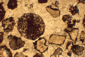 Photomicrograph from the massive volcaniclastic flow - Shards and possible accretionary lapilli. Cements are coarse calcite, that has also replaced some matrix. Field of view 8 mm. 