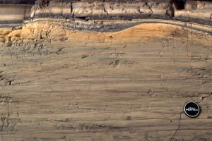 Volcaniclastic sandstone with ripples and climbing ripples. Bedforms in the upper orange-brown layer may have been deposited as antidunes.