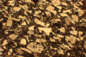 Photomicrograph from the massive volcaniclastic flow - Bubble-wall ash shards, pumice and matrix in finer-grained part of the flow unit. Field of view 3 mm.