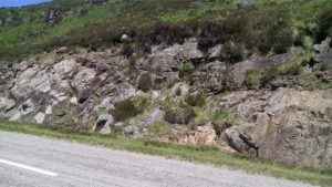 Reddish-grey Torridonian sandstone overlies and onlaps shallow paleotopographic lows on Lewisian gneiss (pale greys).