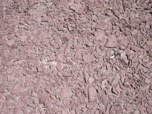 Desert varnish, a common feature of prolonged, arid climate weathering. The varnish consists of silica, iron and manganese slowly leached from the original rock, and re-precipitated as oxides.