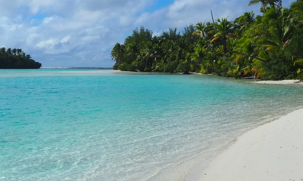 Beach and channel sands merge with the reef apron on Tapuaetai (One Foot Island) along the southeast periphery of Aitutaki carbonate platform (Cook Islands), a delightful spot to while away a few lazy geological hours. To the right is the south end of Tekopua Island and the active channel between the two islands (motu). The main reef is just visible on the horizon. A satellite view of the islets (motu) and channels is shown in the text.