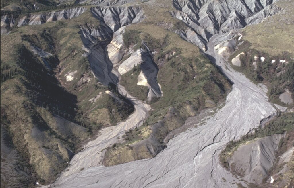 Advancing hillslope dissection in Eocene conglomerate and sandstone can be described in thermodynamic terms as a system increasing in entropy. The resulting sand and gravel are relayed through gullies onto an alluvial fan (the fan head is seen here), that also becomes stratigraphically and sedimentologically more diverse down-fan – attributes that can also be expressed as an increase in entropy and self-organizing. Tertiary Hills, (Mackenzie River valley) Nunavut, Canada.